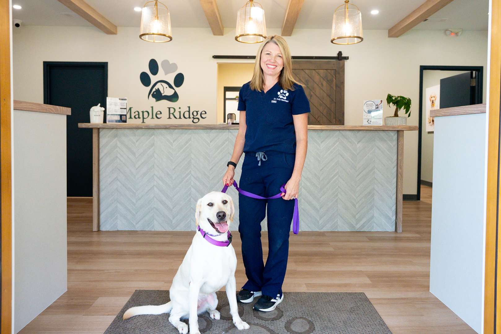 Maple Ridge Animal Hospital team member with a happy, protected patient